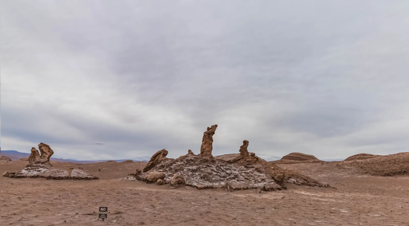 The Tres Marías salt formations stand on the valley floor under a grey sky