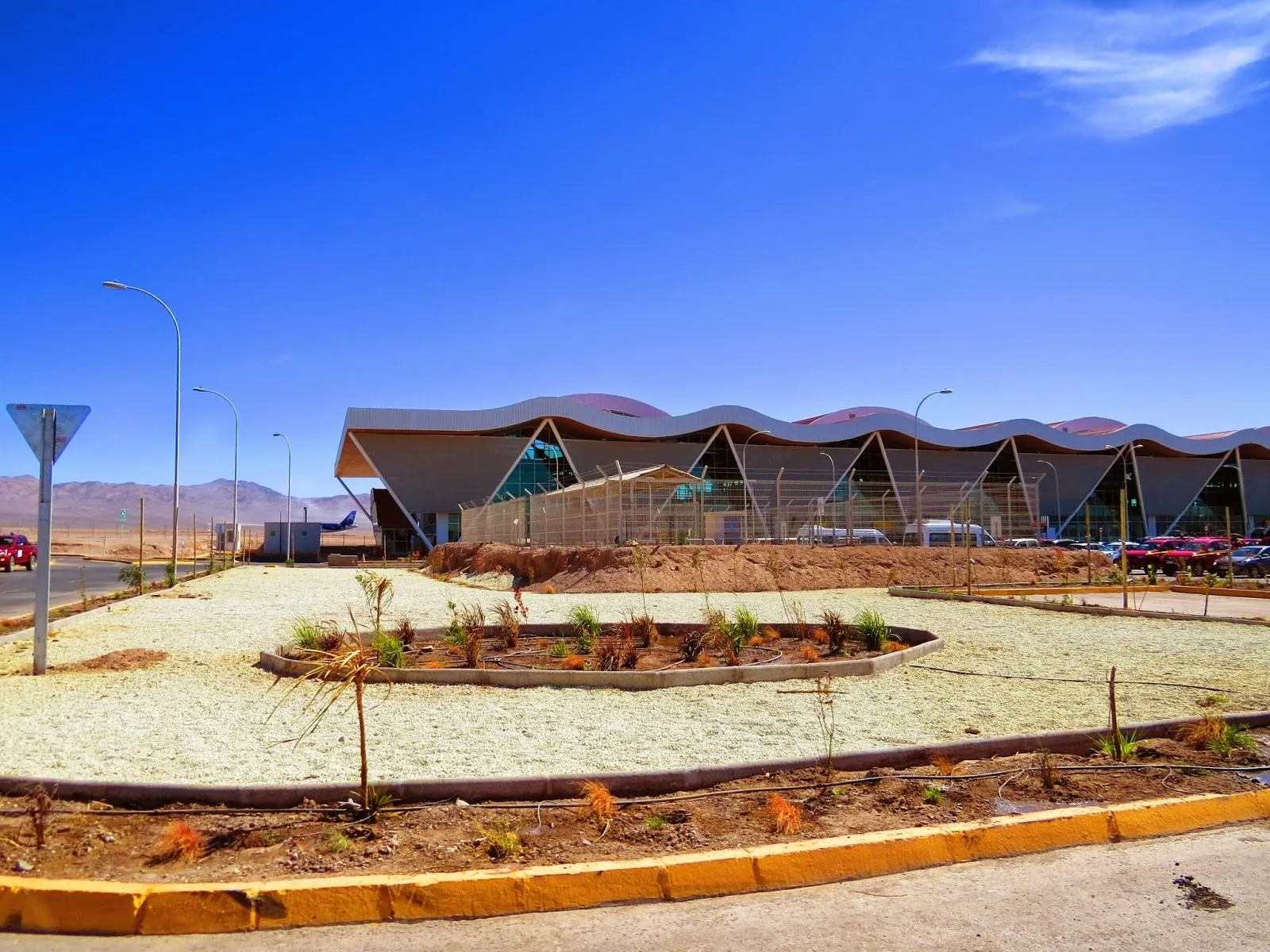 El Loa Airport terminal in Calama, with its wave-shaped roof behind a landscaped car park