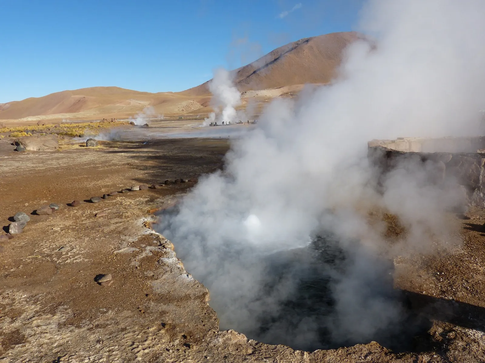 Steam rising from a geyser vent at the El Tatio geothermal field in the early morning