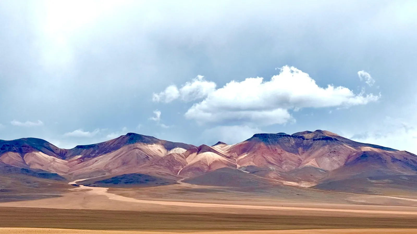 Bands of red, purple and brown colour a range of mountains on the Bolivian altiplano