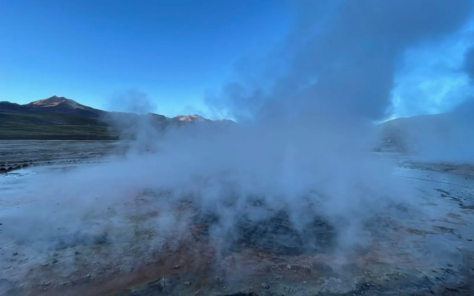 Thick steam covers the El Tatio geyser field in early morning light